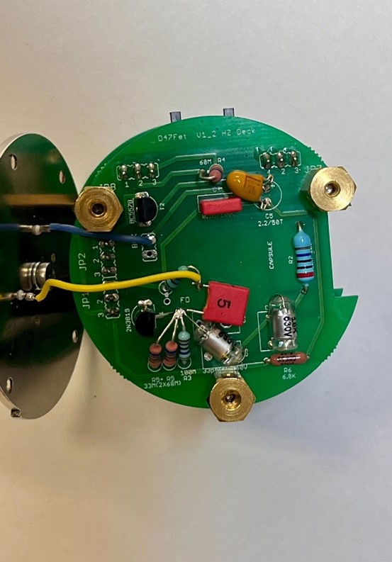 D-47FET top metal capsule plate with Teflon pin installed, yellow front diaphragm wire and blue rear wire visible.