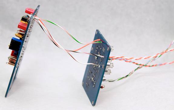 Two D-87 PCBs connected by a bundle of Teflon-jacketed wires, photographed edge-on.