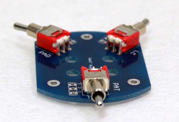 Completed D-87 switch PCB with three through-hole toggle switches soldered in place.